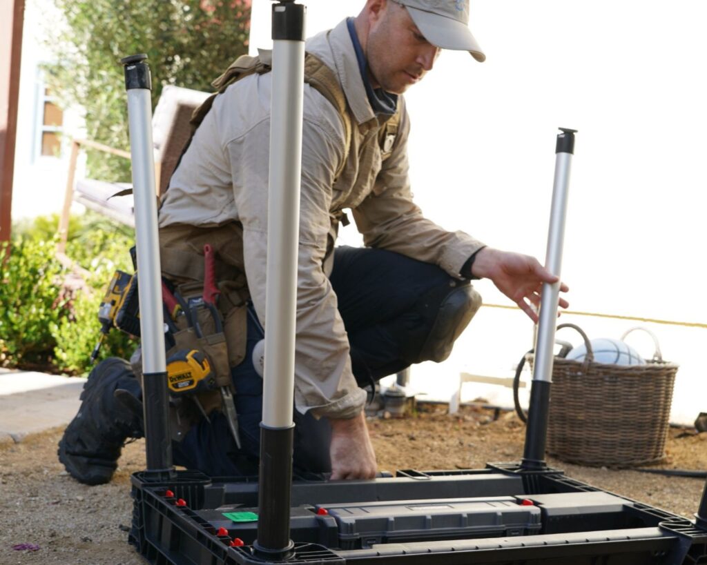 Pest control technician installing outdoor rodent monitoring station